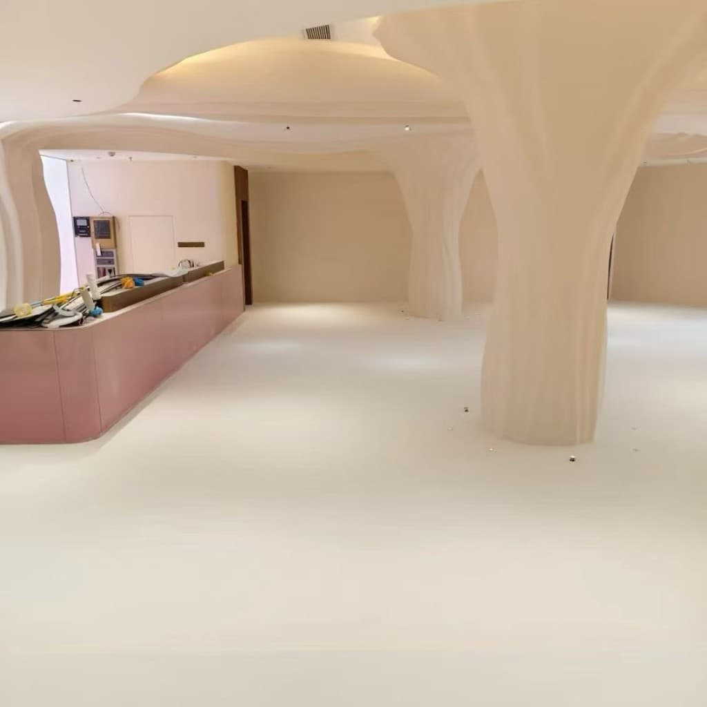 Actual hotel installation: sculpted microcement columns flow into a continuous warm-white lobby floor